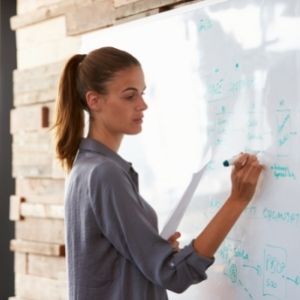 Women in office using whiteboard pen on whiteboard